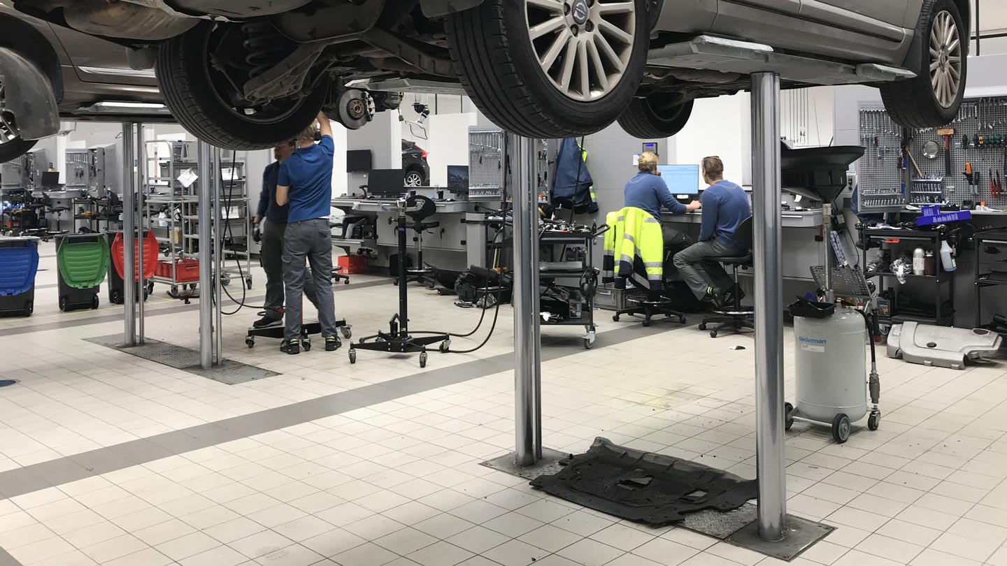 Interior of a Volvo workshop with cars being serviced by technicians