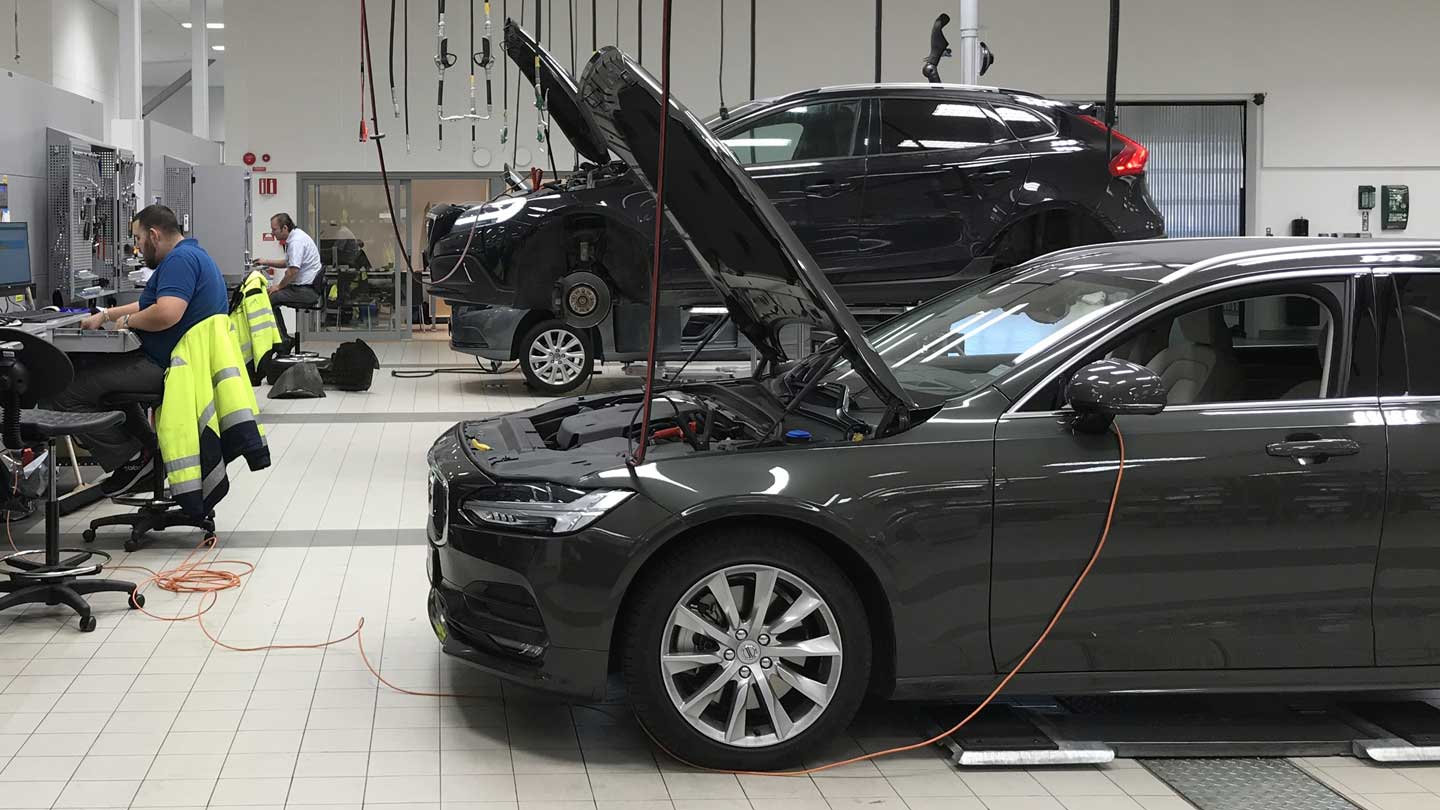 Interior of a Volvo workshop with cars being serviced by technicians